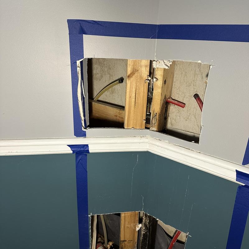 Shower valve plumbing exposed behind opened wall panels