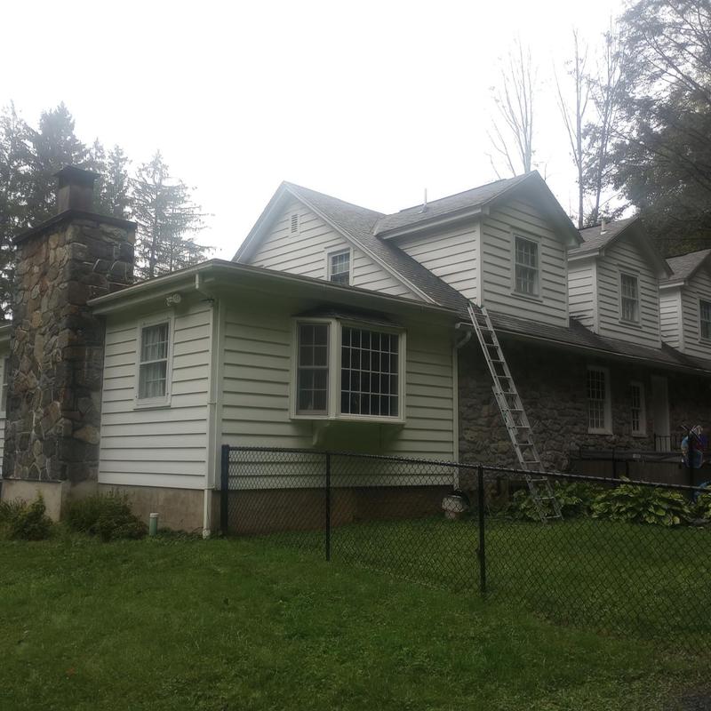 Roof shingles inspection with ladder on house exterior