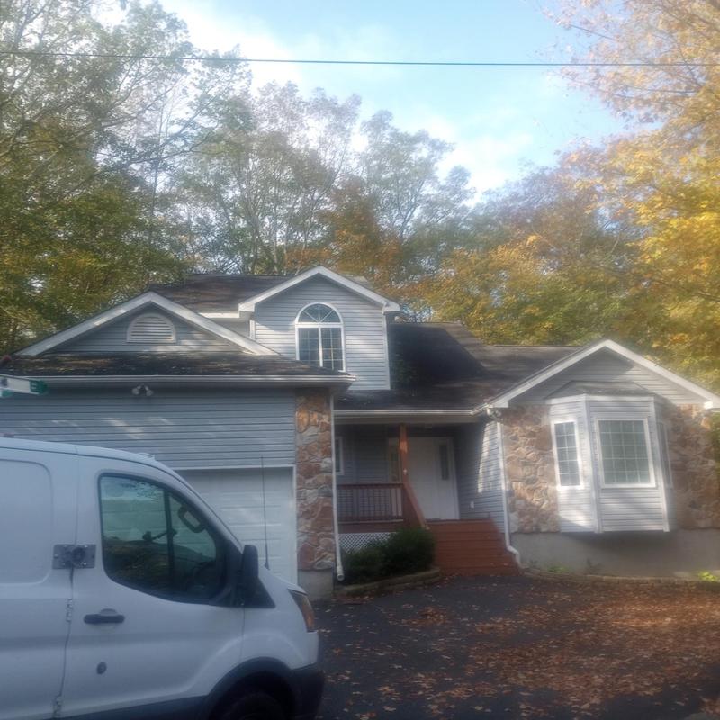 Roof shingles inspection with service van in driveway