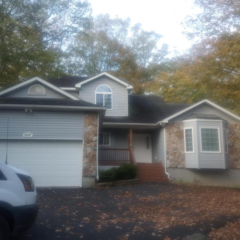 Roof shingles with moss and damage on house roof