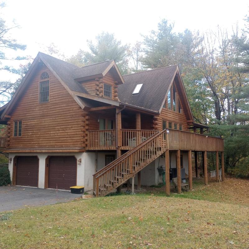 Log cabin roof with skylight and shingle roofing inspection