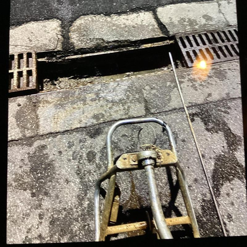 Street drain clog with plumbing snake tool in use