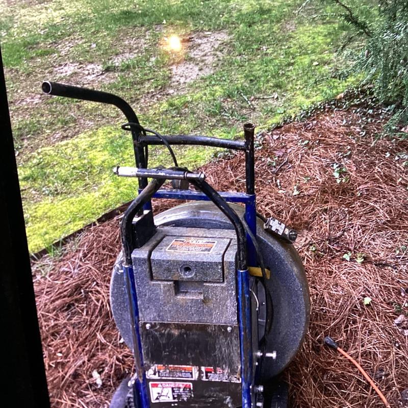 Sewer line drain cleaning machine outdoors on pine straw