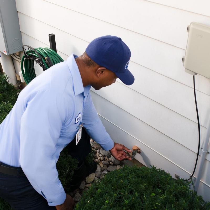 Outdoor hose bib inspection by plumber outside apartment