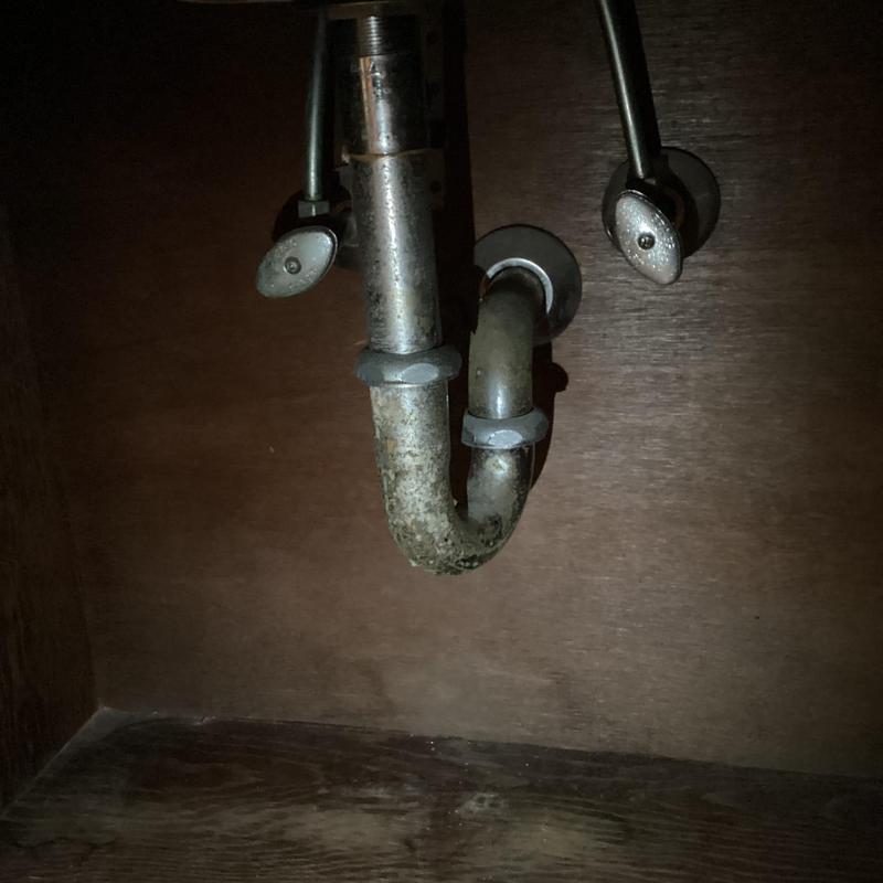 Bathroom sink P-trap with corrosion under cabinet