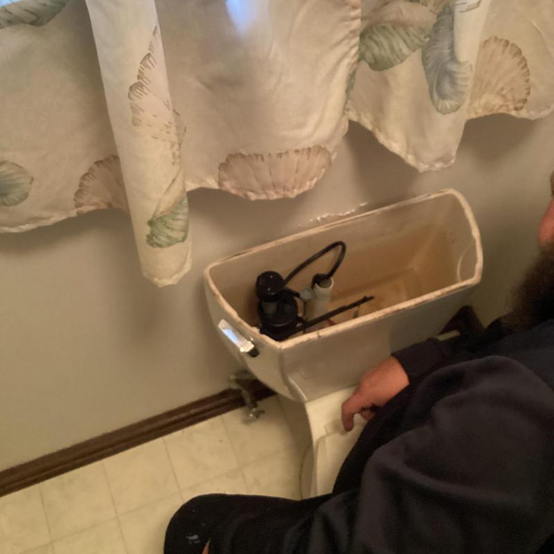 Toilet flush mechanism repair in bathroom
