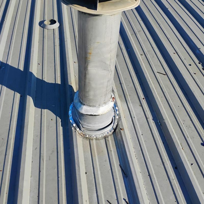 Metal roof vent pipe flashing with hail damage on roof