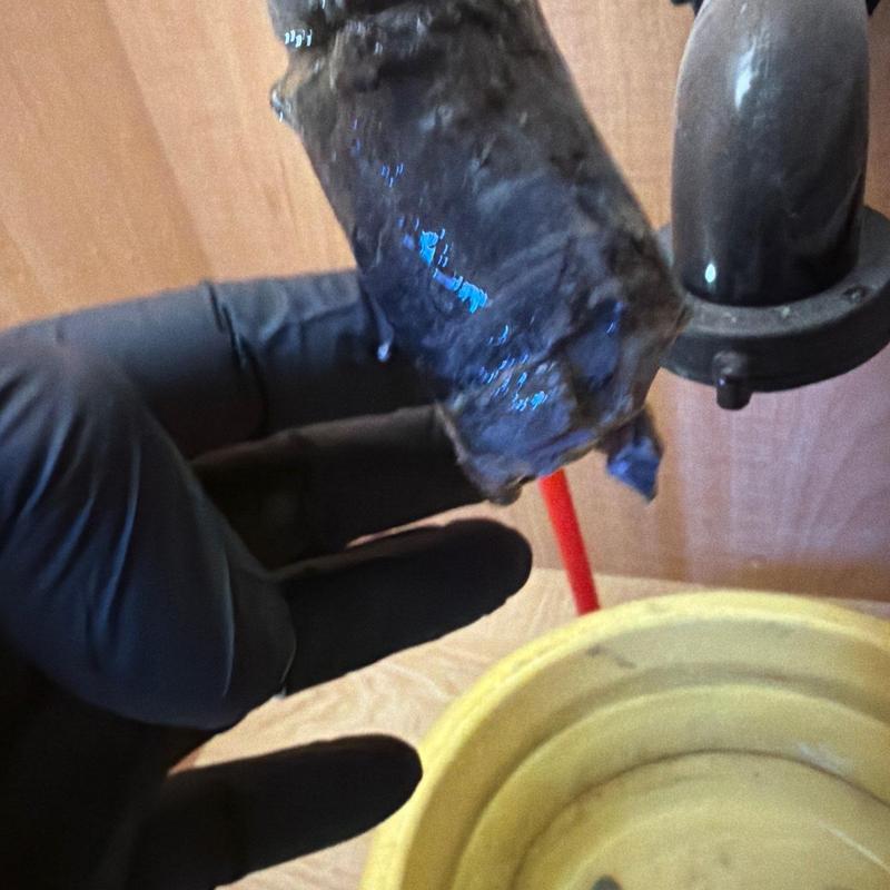 Sink drain pipe with clog removal in progress