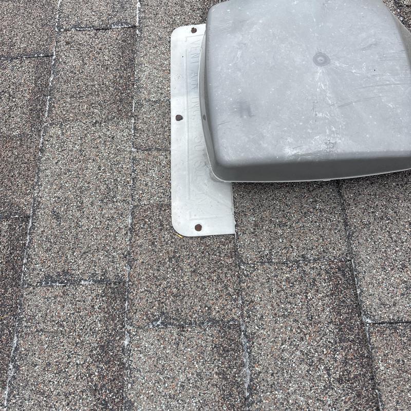 Asphalt shingle roof vent with plastic cover on rooftop