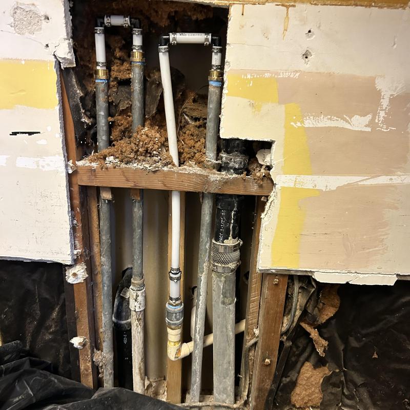 Kitchen plumbing pipes behind wall studs during remodel