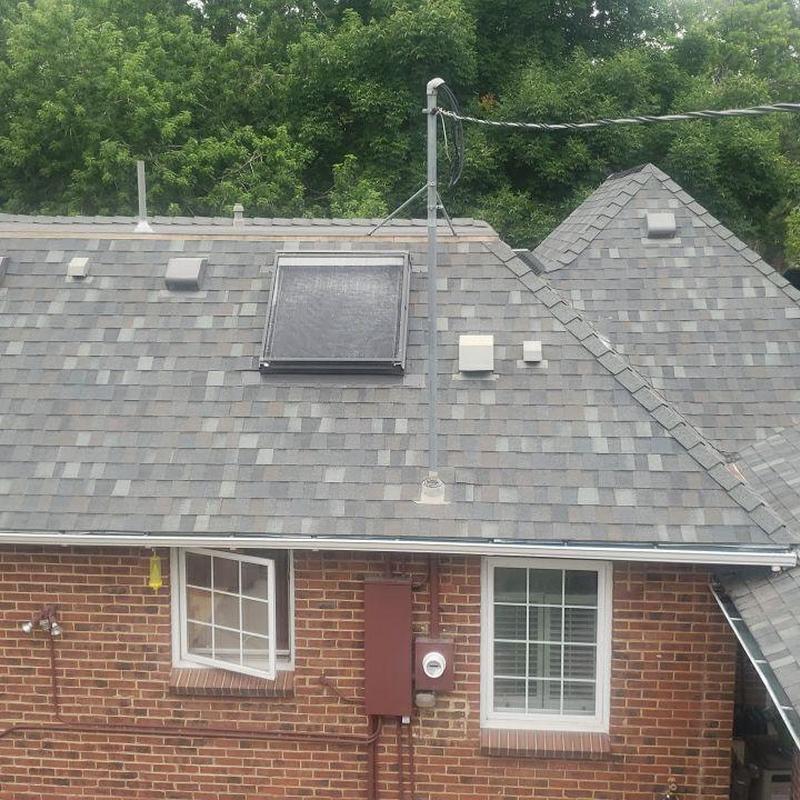 Asphalt shingle roof with solar vent and electrical meter