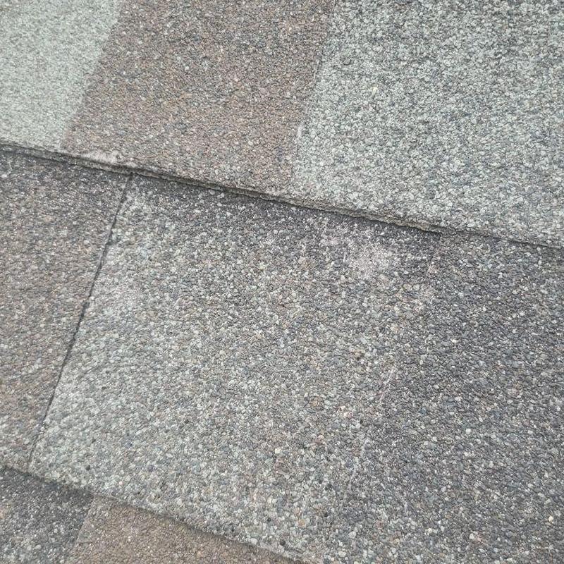 Asphalt roof shingles with hail damage close-up
