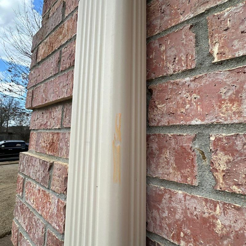 Vinyl downspout with scratch on brick wall background