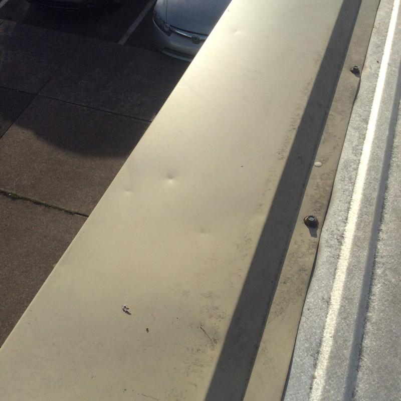 Metal roof panel showing hail dents and wear