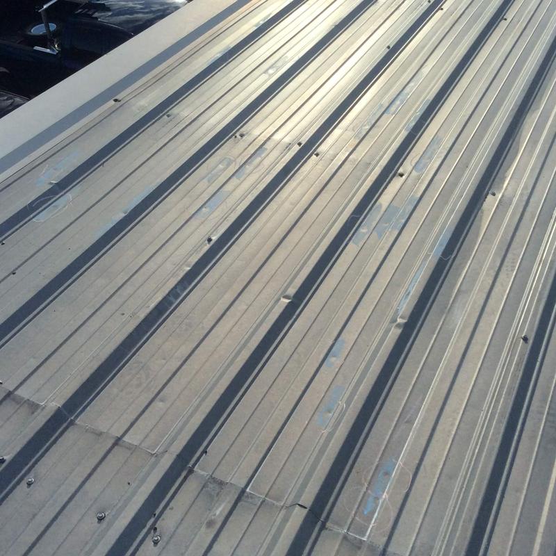 Metal commercial roof with hail damage and dents