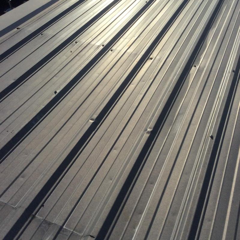 Metal roofing panels with visible hail damage dents