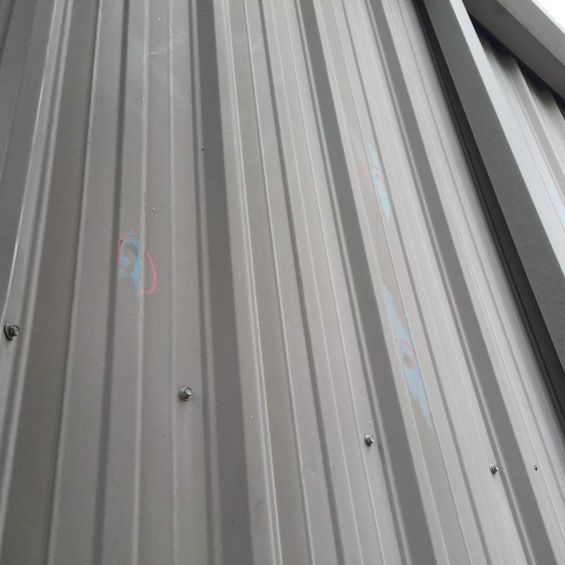 Metal roofing panels with hail damage markings