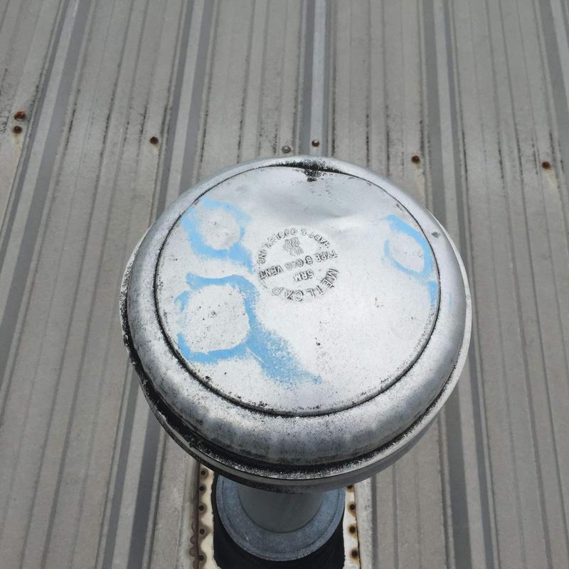 Metal roof vent with weathering and markings on roof