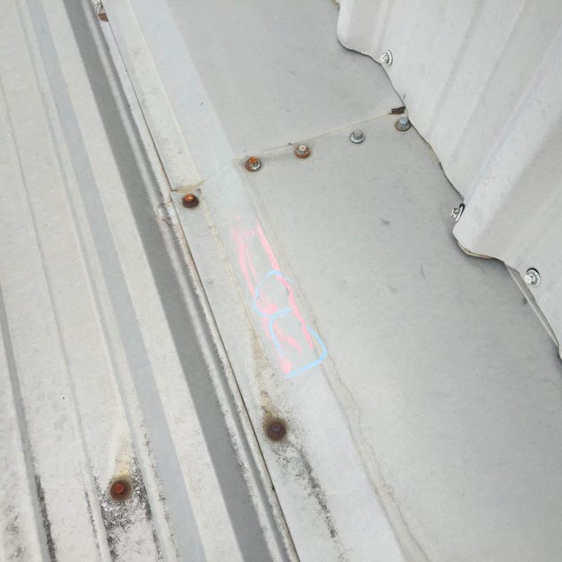 Metal roof panels with rusted fasteners and markings