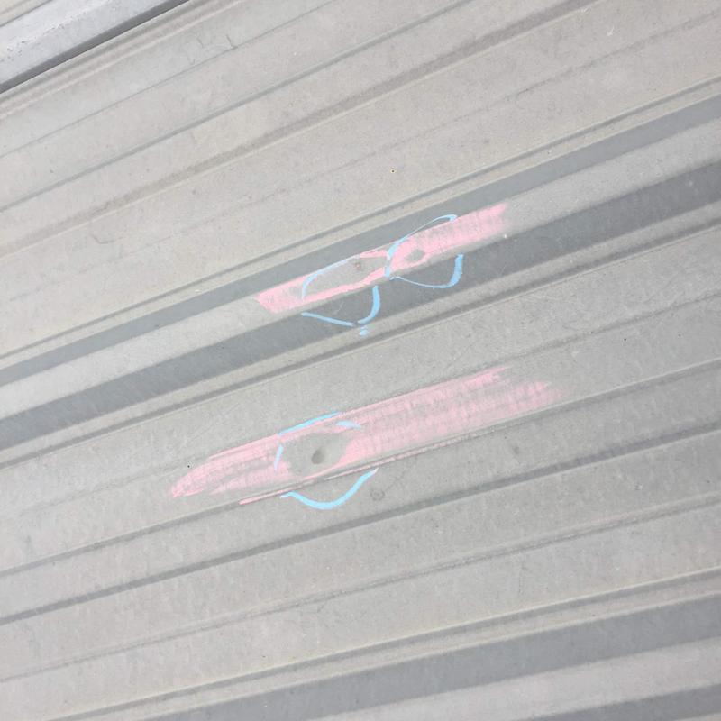 Metal roof hail damage marked for repair