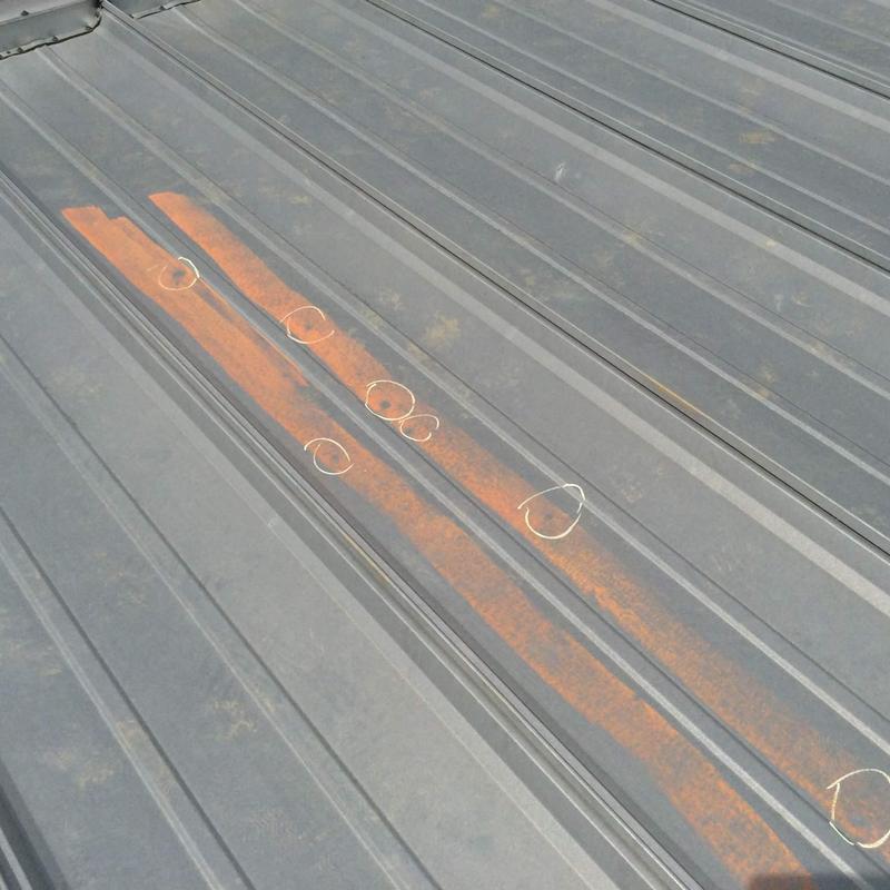 Metal roof panel with rust and hail damage marks