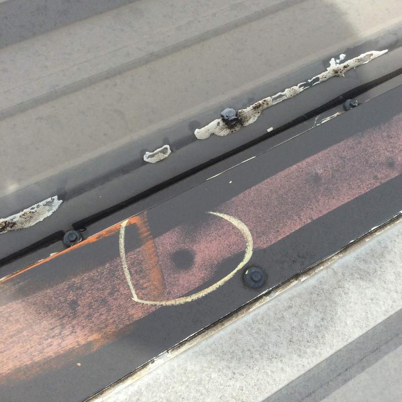 Metal roofing panel with hail damage and sealant wear