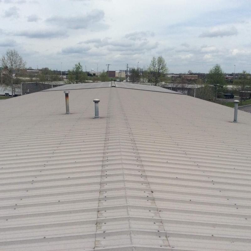 Commercial metal roofing with vent pipes and hail damage