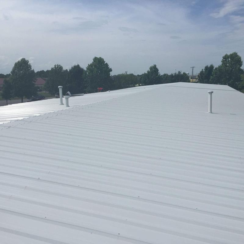 Commercial metal roof with hail damage and wear