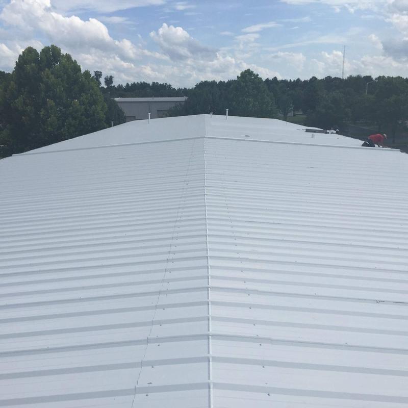Metal commercial roof with hail damage and membrane wear