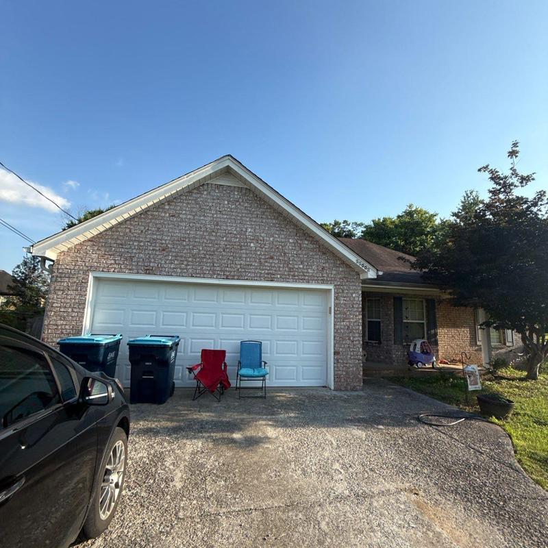Garage door exterior with driveway and chairs