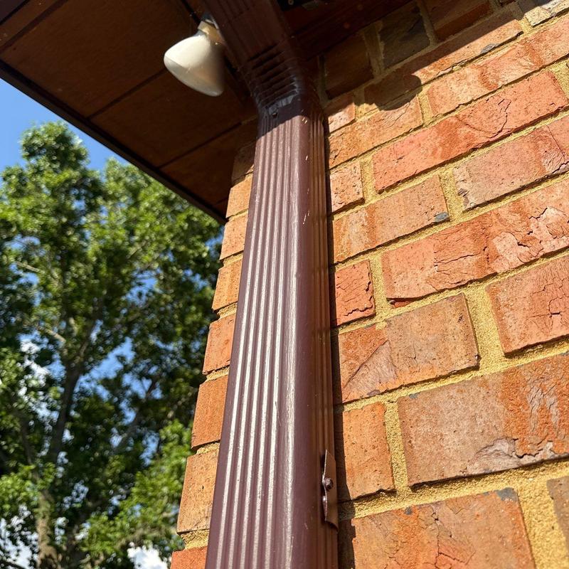 Storm drain downspout damaged on brick exterior wall