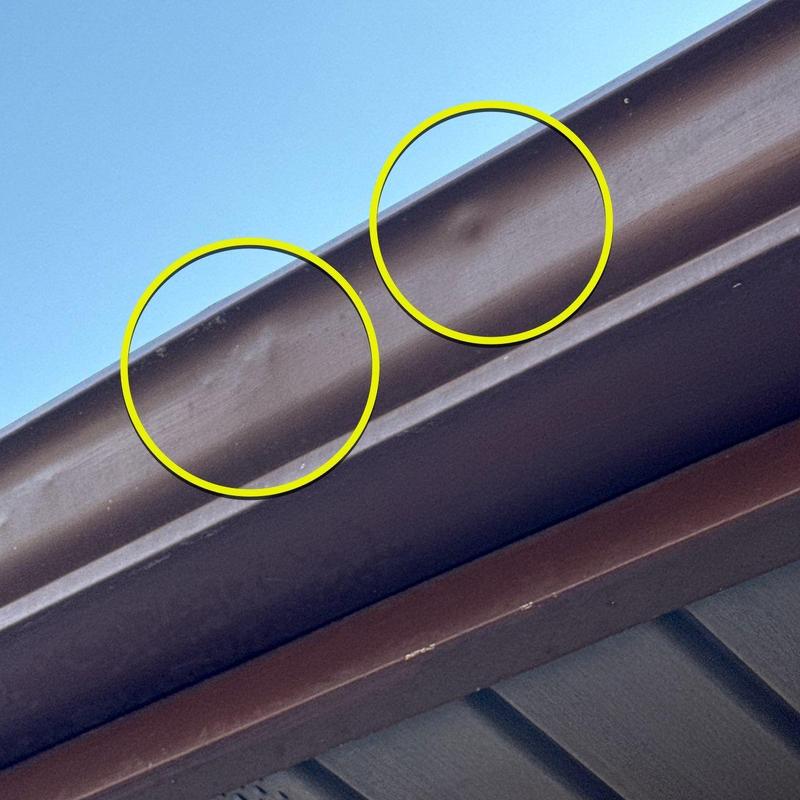 Metal gutter with hail dents marked in yellow circles