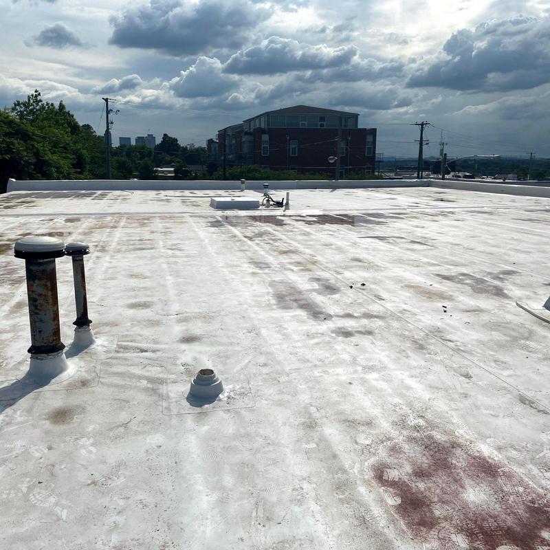 Commercial flat roofing with hail damage and wear marks