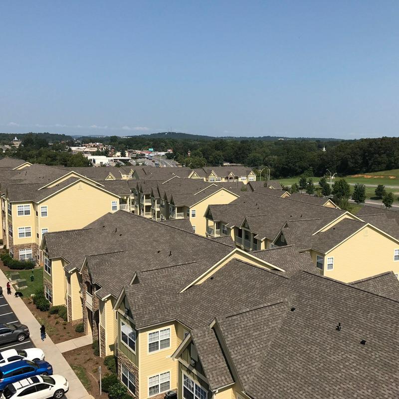 Asphalt shingle roofs showing hail damage on apartments
