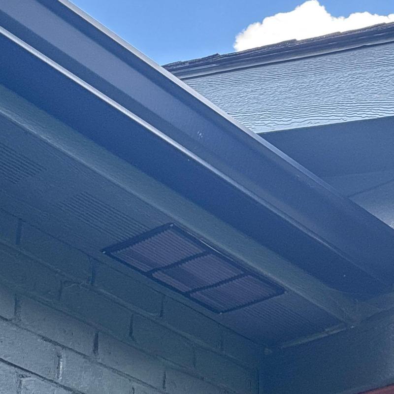 Roof soffit vent and gutter system on brick wall