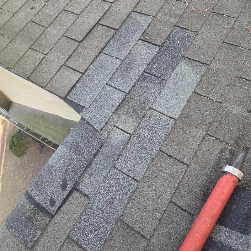 Roof shingles and ridge caps with caulking gun nearby