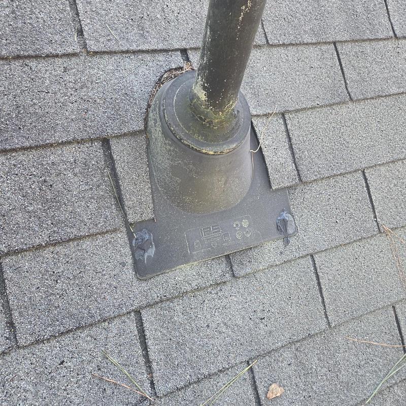 Roof vent pipe flashing with caulk on asphalt shingles