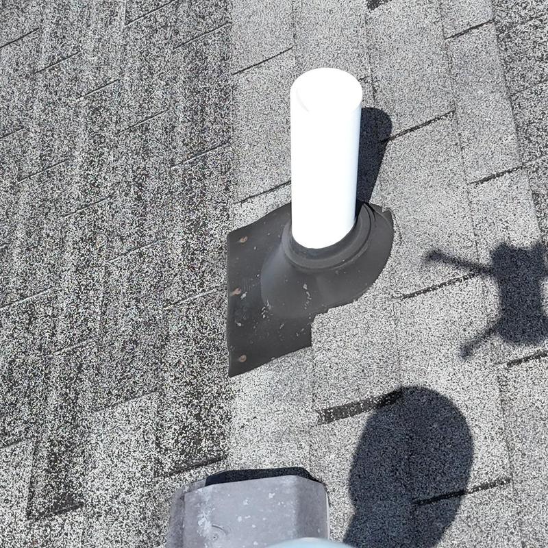 Pipe boot on shingle roof with replaced shingles and caulking