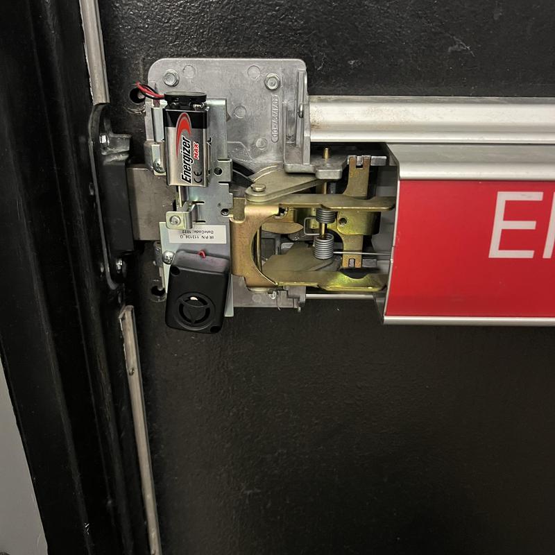 Panic bar lock mechanism with battery installed