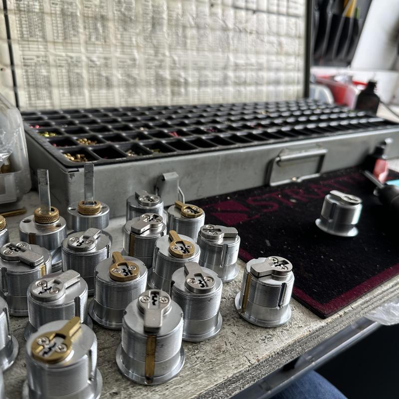 Cylinder lock cores and key cutting tray on workbench