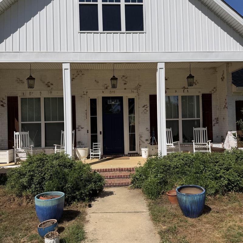 Front porch columns with white rocking chairs and planters