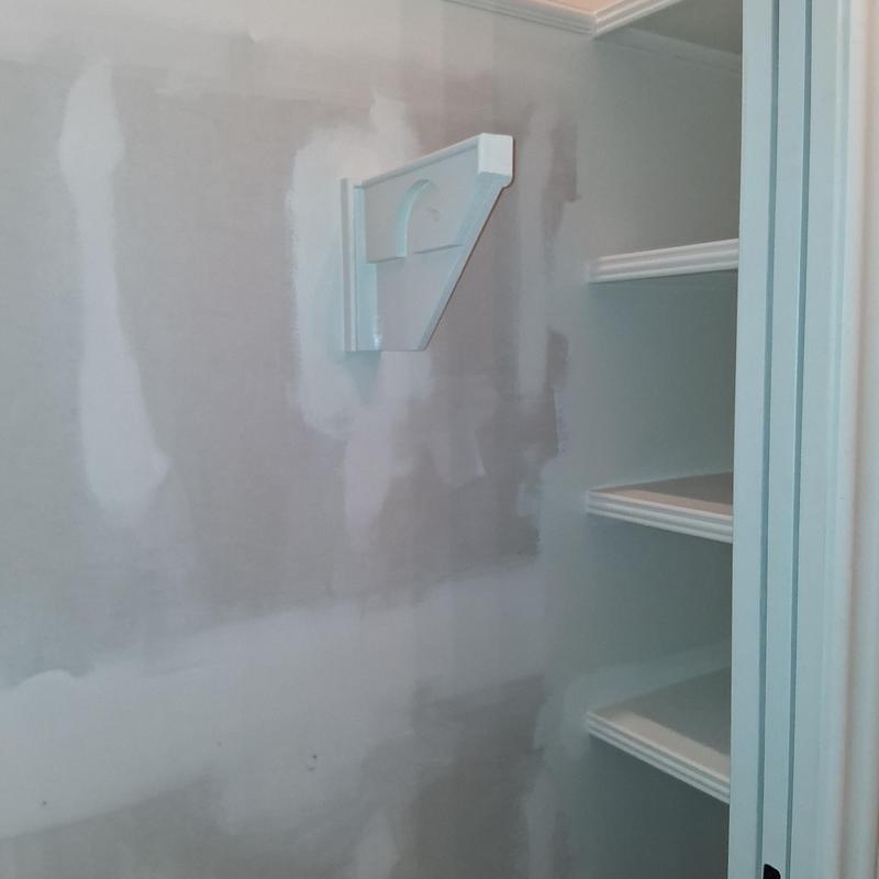 Wall patching and painting near shelving unit