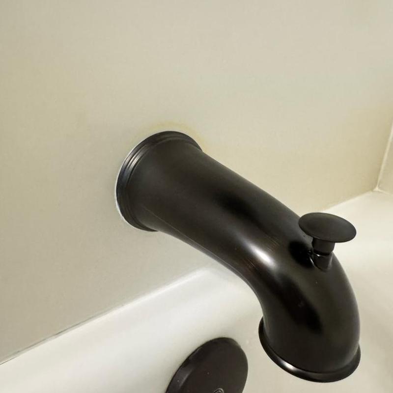Black tub spout with diverter installed in bathroom