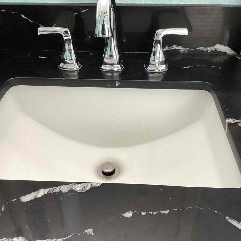 Bathroom faucet and sink with black countertop