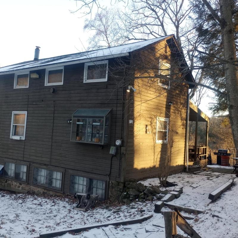 Roof shingles and flashing inspection on snowy house exterior