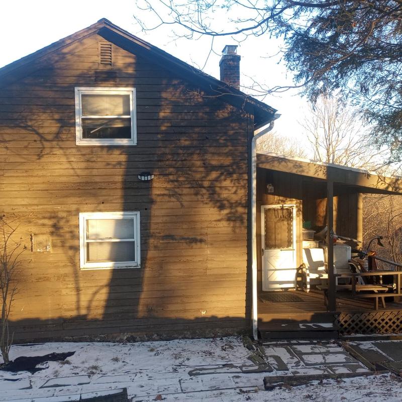 Gutter and downspout inspection on brown house exterior