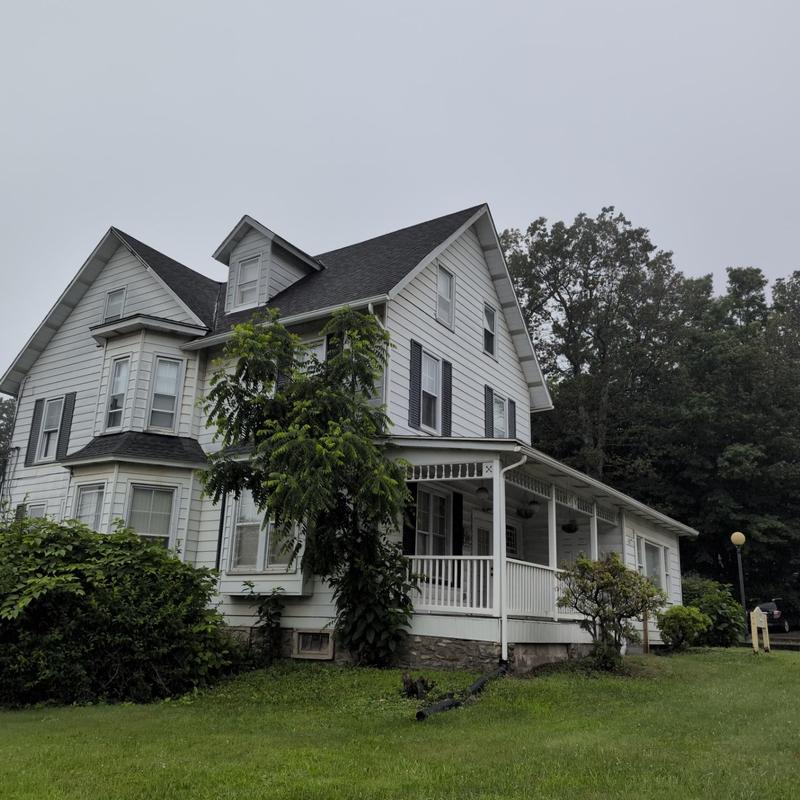 Asphalt shingle roof inspection on white house