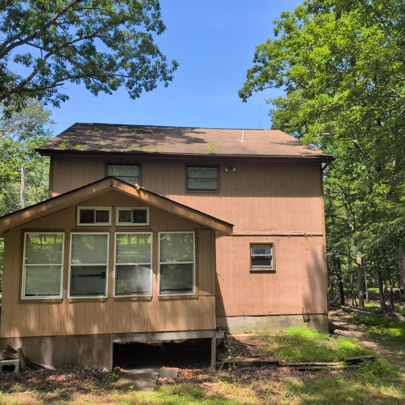 Asphalt shingle roof inspection on house in forest