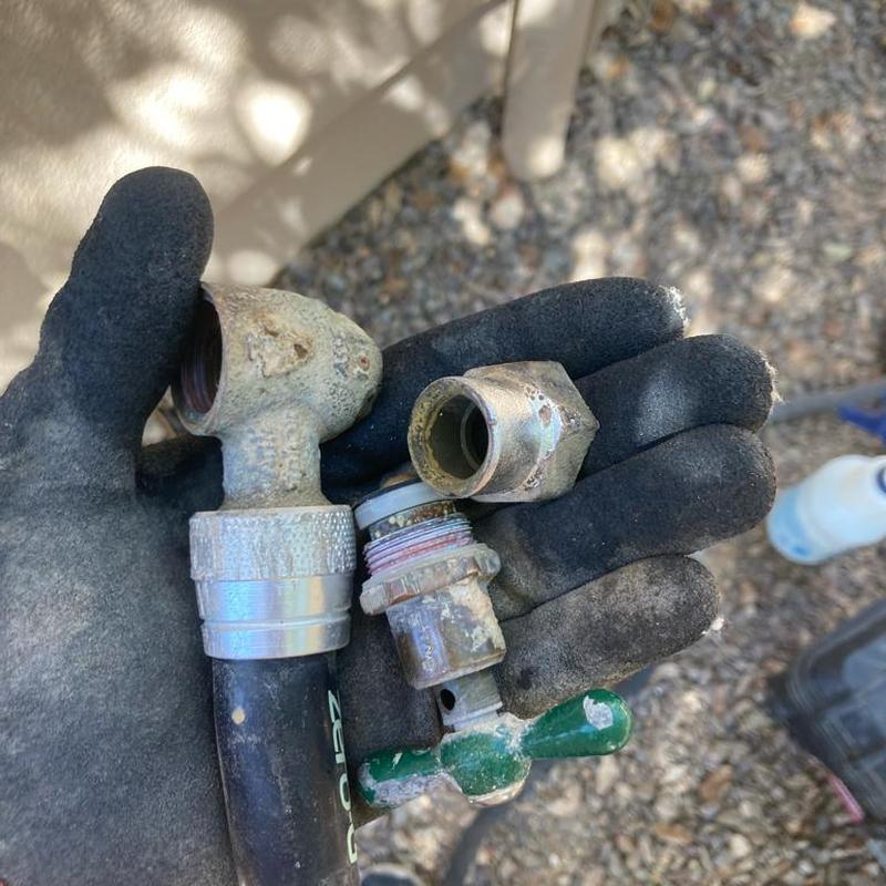 Frozen outdoor hose bib parts held in gloved hand