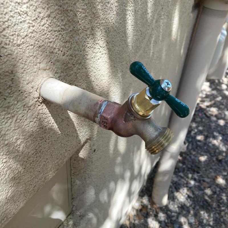 Outdoor hose bib installation on house exterior wall